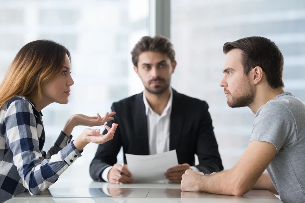 Annoyed unhappy married couple arguing in lawyers office get divorced