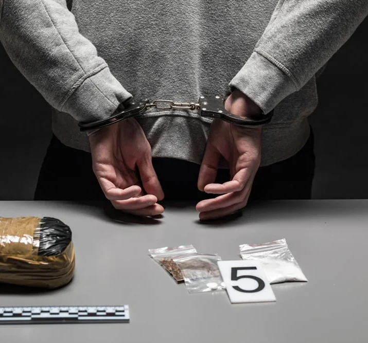 hands of a male drug dealer are handcuffed. The fight against drugs and crime.