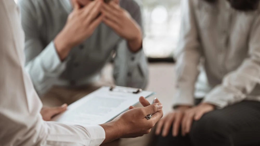 Doctor or psychologist filling medical patient information form holding clipboard