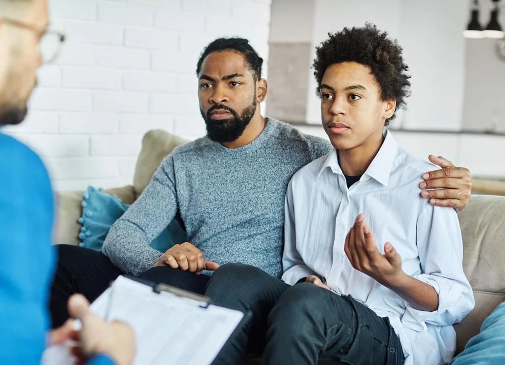 Father with his teenage son at meeting with social worker,
